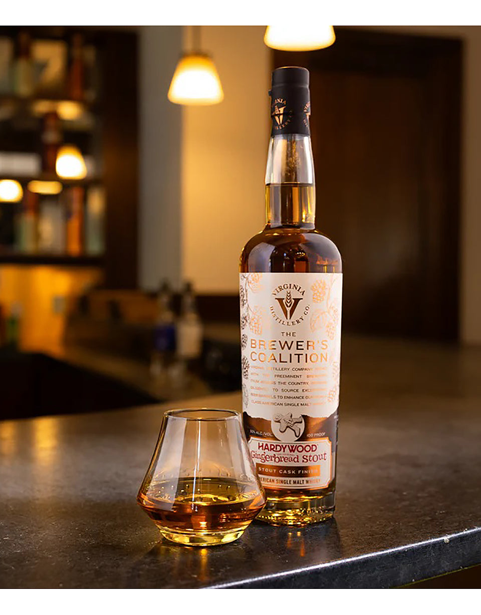 Bottle of Hardywood The Brewer's Coalition whiskey on a bar with a glass filled with whiskey.