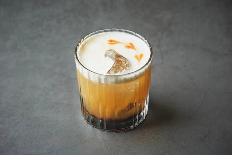 Amaretto Sour cocktail with lemon and cherry garnish