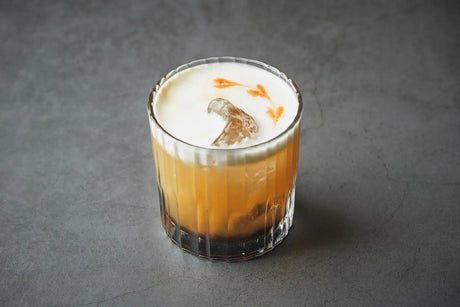 Amaretto Sour cocktail with lemon and cherry garnish
