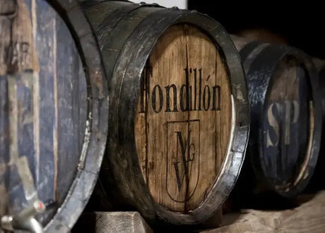 Oak barrels aging distilled spirits in a warehouse