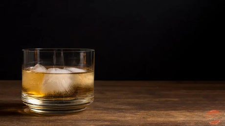 Boulevardier cocktail with orange peel beside whiskey