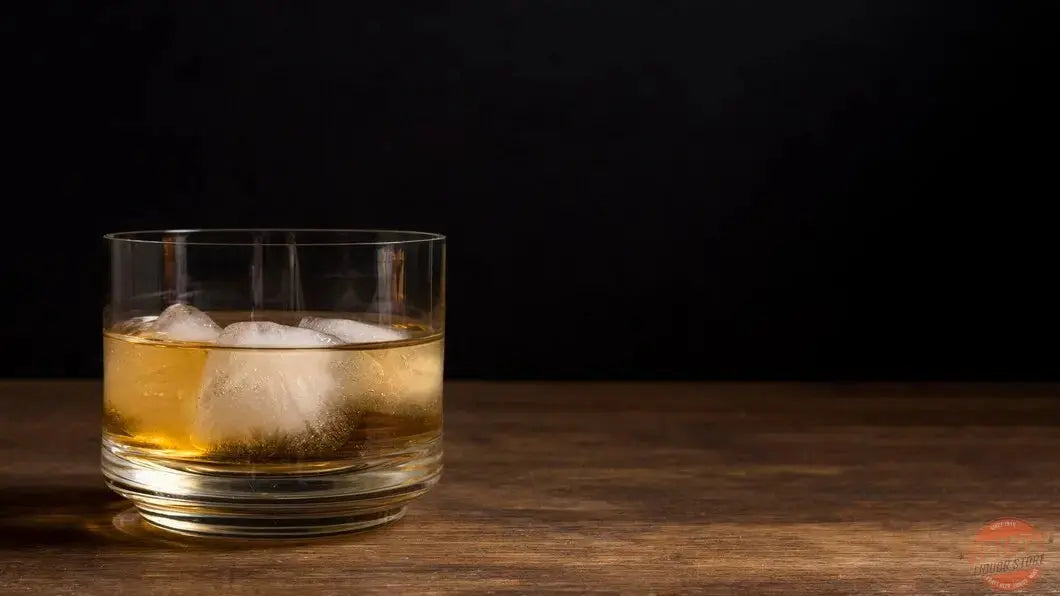 Boulevardier cocktail with orange peel beside whiskey