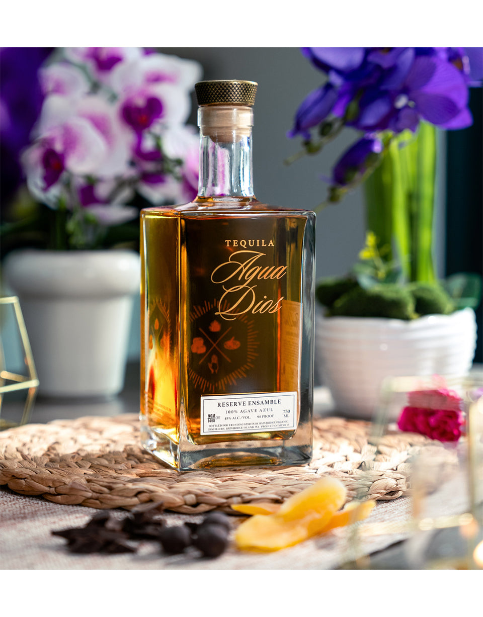Tequila bottle labeled 'Aguas Dios' on a table with decorative elements