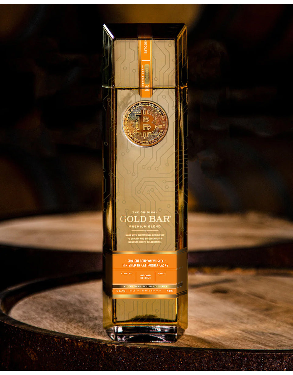 Gold bar-shaped bottle of whiskey on a wooden barrel with a dark background