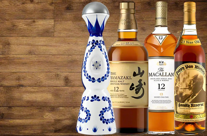 Four bottles of different types of whiskey on a wooden background