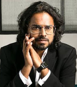 Man in a suit sitting on a bench with a neutral background